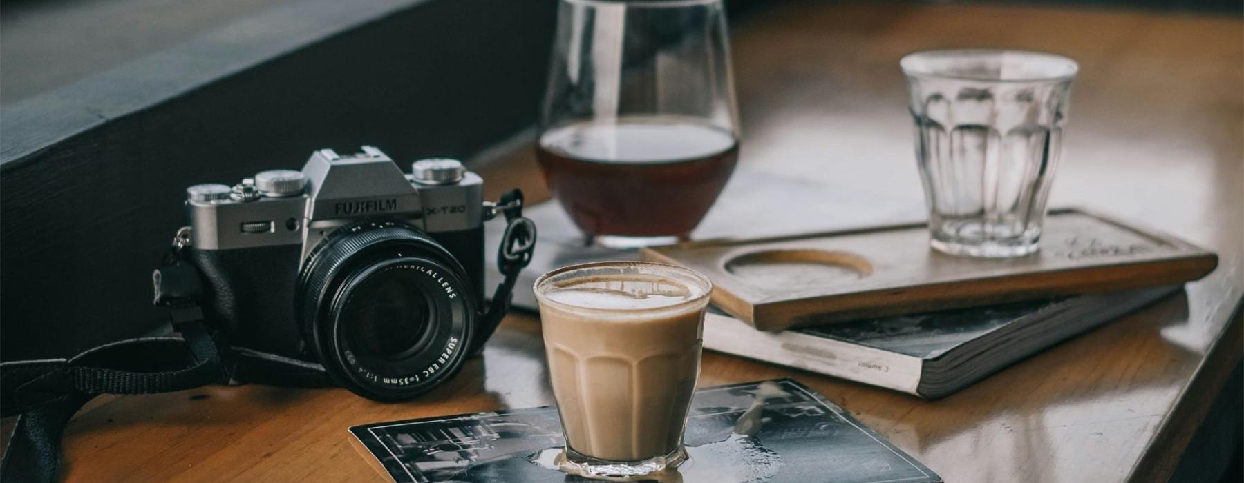 a camera and cup of coffee on a table