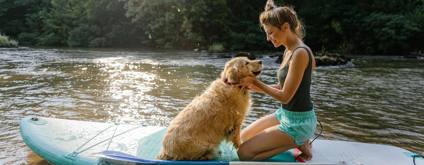 a person and a dog on a canoe in a lake