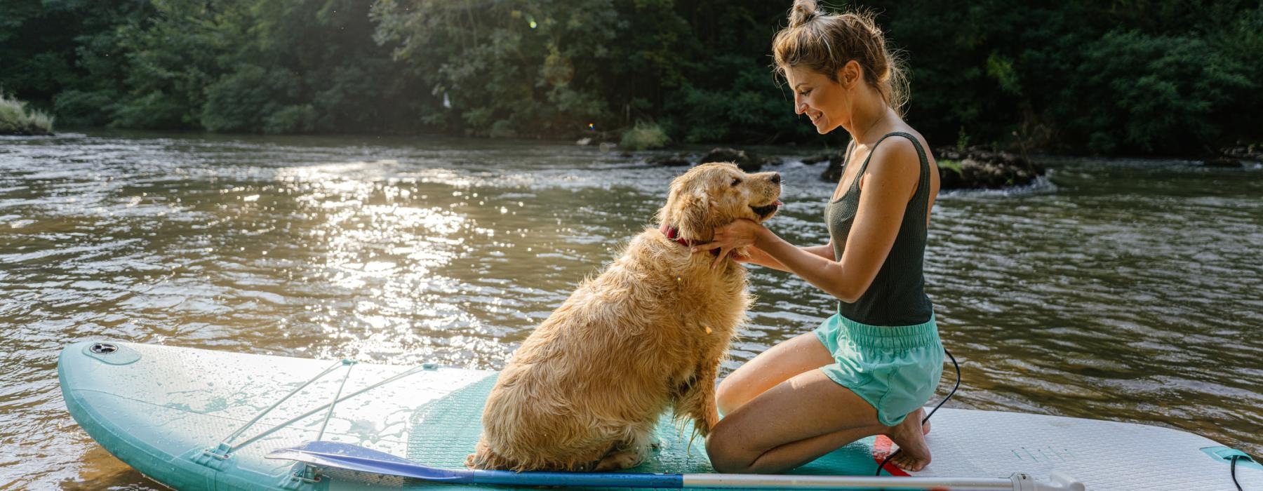 a person and a dog on a canoe in a lake